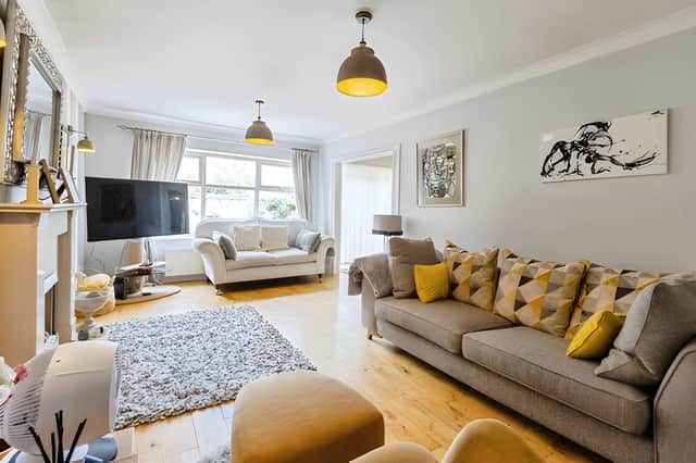 The spacious lounge flows towards a snug or dining area, with patio doors creating a direct link to the rear garden