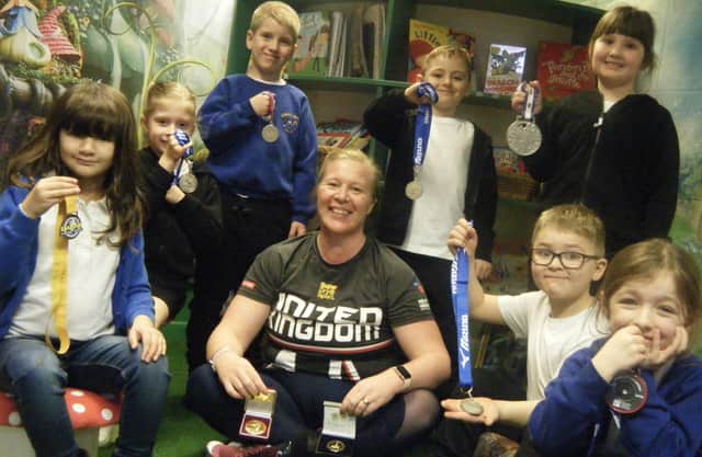 Athlete Caroline Buckle shares her medals with Airedale Infant School pupils.