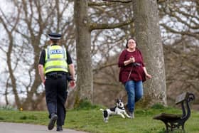 A policeman walks past a woman exercising with a dog in Roundhay Park, Leeds, as the UK continues in lockdown to help curb the spread of the coronavirus. Picture: Danny Lawson/PA
