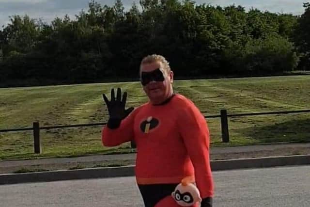 Mr Incredible waves as he walks past