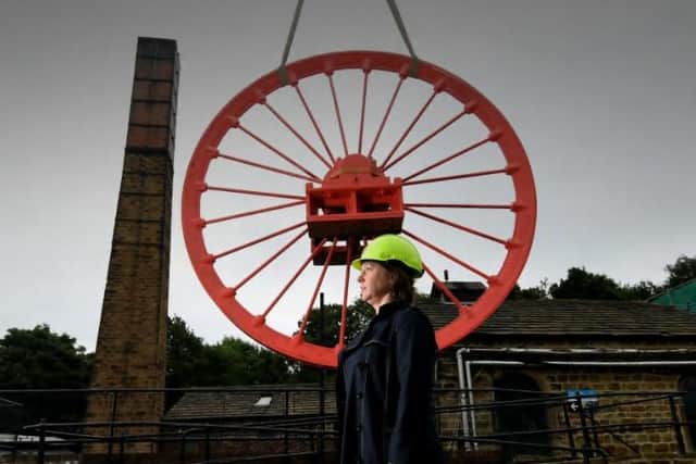 Museum Director Jenny Layfield is pictured with the wheel.