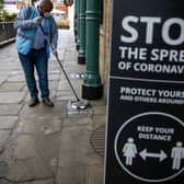 A man cleans social distancing markers as further coronavirus lockdown restrictions are lifted in England. Photo: PA