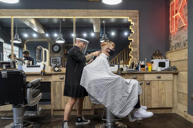 Lisa de Csernatony cuts a customers hair at Kraft Barbers.