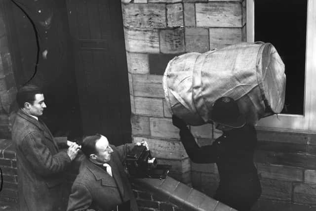 A policeman carries evidence, wrapped in canvas, into the court at Horsham, Surrey, for the case of 'The Acid Bath Murders' involving John Haigh. (Photo by Don Price/Getty Images)
