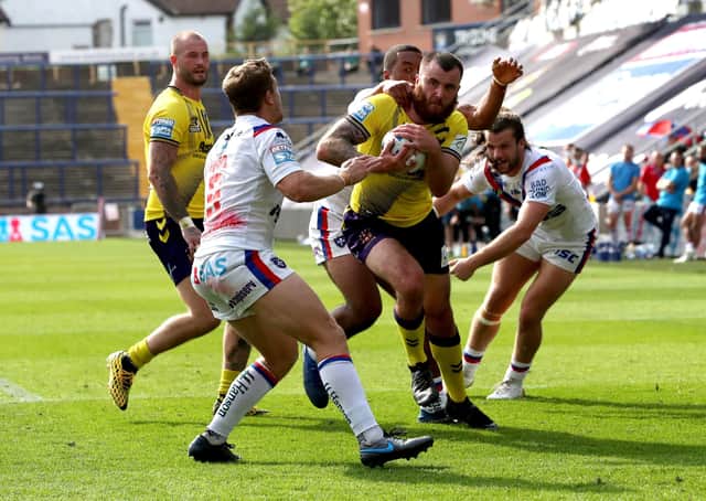 Wigan Warriors' Jake Bibby (second right) goes over for a try against Wakefield. Picture: PA.