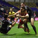 St Helens' Tommy Makinson (centre) powers through the tackles from Wakefield Trinity's Max Jowitt (right) and Alex Walker to score a try.