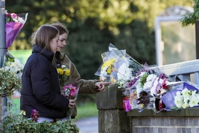 Two young girls pay their respects at the scene.