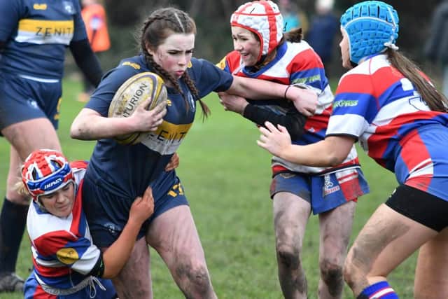 Frankie Blakey (left) leads some determined Castleford U15s tackling with Lexie Hagues and Olivia Phelan lending support.