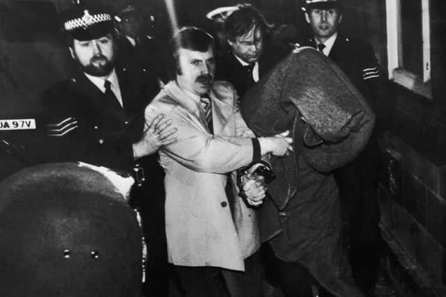 His head covered with a blanket, Peter Sutcliffe, aka 'The Yorkshire Ripper', is escorted into Dewsbury Magistrates Court to be charged with murder on January 6 1981. (Photo by Jack Hickes/Keystone/Hulton Archive/Getty Images)