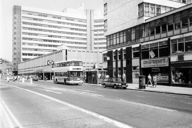 Woodhouse Lane showing the Merrion Centre. Newarke Wools is on the right followed by a shop to let that was previously occupied by Centresport. Lloyds Bank is at the end of the row before the entrance to the shopping centre, with Morrisons supermarket following on from this.