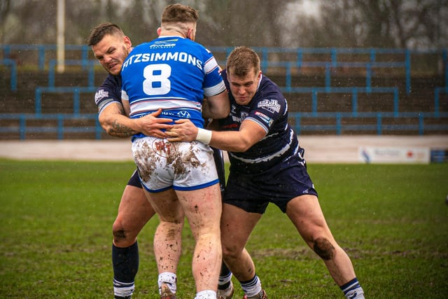 Workington Town's former Castleford Tigers player Conor Fitzsimmons is stopped in his tracks by two Featherstone Rovers tacklers. Picture: Dec Hayes