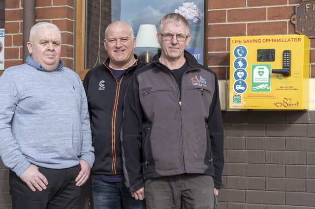 campaigners: The defibrillator outside The Eagle pub on Methley Road in Castleford, from left: Tony Carlin, Darren Moore and Terry Bilsbrough.