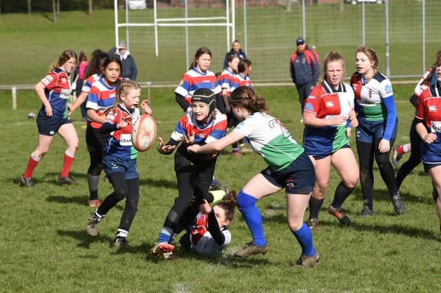 Lilly Platt moves the ball out to supporting players in Castleford RUFC U13s’ game against Hull Ionians. Pic: Daniel Rowlinson