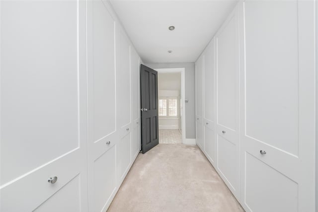 The principal suite has this amazing dressing room with fitted wardrobes and access to the en-suite shower room and main bedroom accommodation.