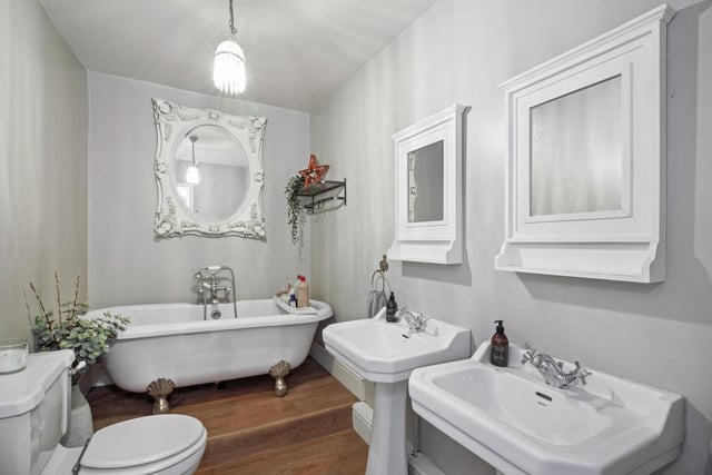 A period bathroom suite includes a free standing bath tub.