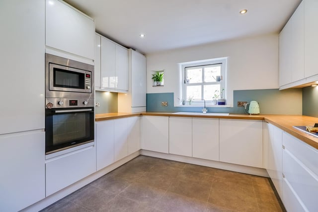 Fitted base and wall units with integrated appliances in this light and bright kitchen.