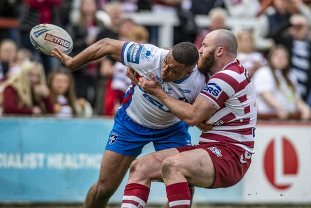 Wakefield's Reece Lyne gets an offload away despite a tackle from Wigan Warriors' Jake Bibby. Picture Tony Johnson