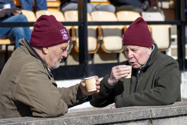 Emley AFC supporters enjoy a drink at the match.