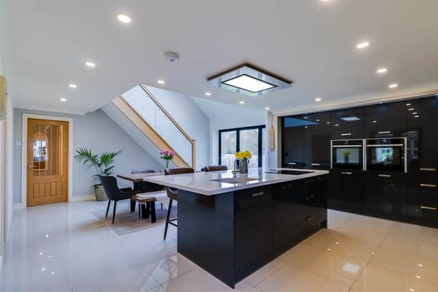 A sleek and srtunning pen plan kitchen with feature oak staircase leading up to a galleried landing.
