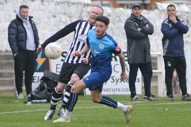 Wakefield AFC man of the match Jock Curran challenges for the ball while watched by manager Gabriel Mozzini.