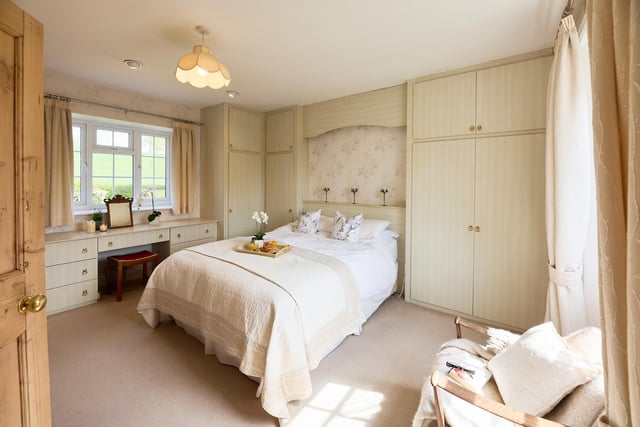 This bedroom with a countryside view has fitted furniture.