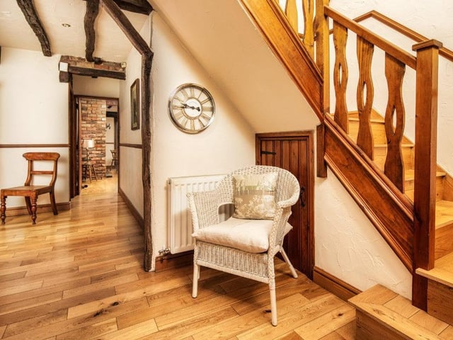 A wooden angled staircase leads up to the first floor from the hallway.