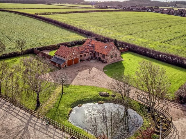 An overview of the extensive property and grounds, with lawns and pond.