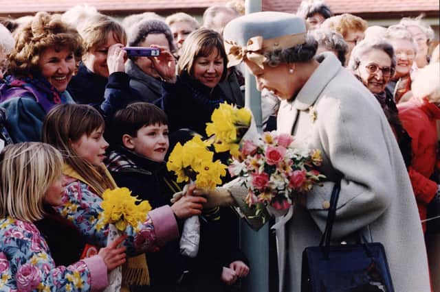 Children say it with flowers as the Queen meets the people outside Wakefield Hospice, 1992.