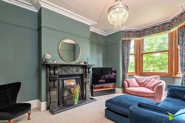 A lovely marble fireplace surround and a large bay window are features of this comfortable sitting room.