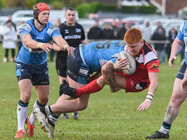 Fryston Warriors' Louie Tomlinson is stopped in his tracks by Featherstone Lions player Jake Roberts in the Castleford Cup semi-final. Picture: Jonathan Buck
