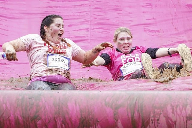 Down the muddy slide for these ladies.