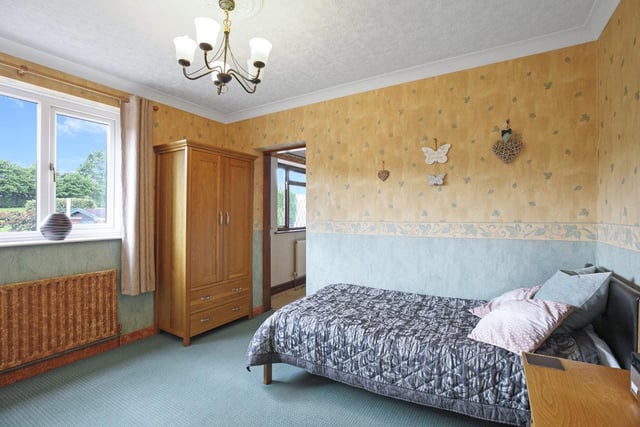 One of the property's double bedrooms, with windows looking over the gardens.