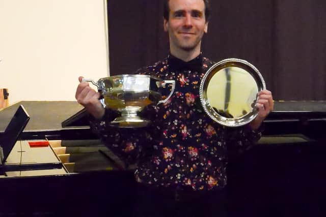 Edward Whelan with two of the trophies the choir won in a competition in Whitby this year.