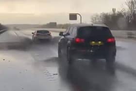 The video shows cars driving through standing water on the M62
