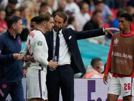England's coach Gareth Southgate talks to Jack Grealish before bringing the player off the bench.