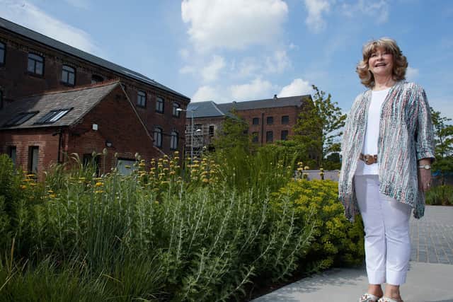 Councillor Denise Jeffery, Leader of Wakefield Council, is seen in the Hepworth Wakefield gardens, with Tileyard North behind her.