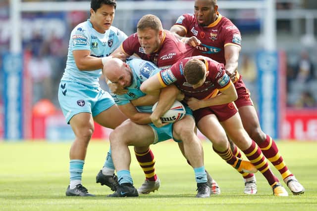 Wakefield Trinity's Lee Kershaw is smothered by Huddersfield Giants' defence. (ED SYKES/SWPIX)