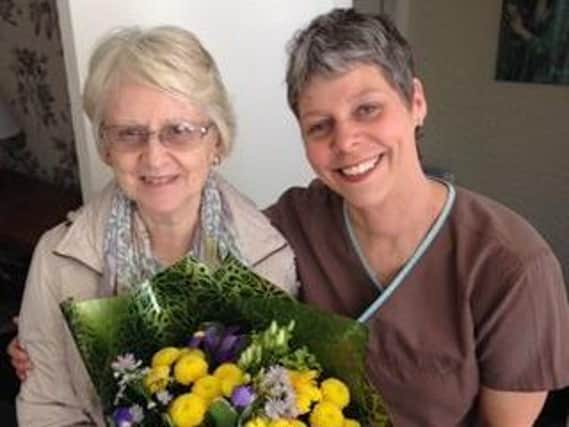 Ginette Bennett with Margaret, one of her patients. Ginette surprised her with a bouquet of flowers on her birthday.
