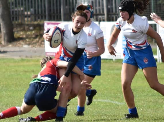 Castleford RUFC U18s’ Ebony Mothershaw is thwarted by a good tackle from a Hull Ionians player. Picture: Richard Gould