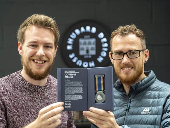 Alex McIntosh and James Lodge of  Rhubarb Design House with the NHS Covid medal they designed