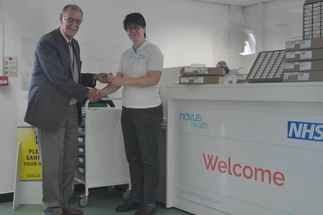 Zone chairman Lion Keith Smalley receives the hearing aids from Heidi Tanton of Novus Health