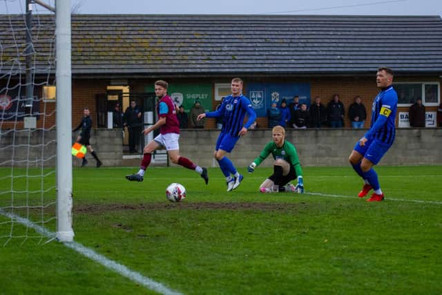 Emley's Joe Jagger beats Goole AFC goalkeeper Dylan Parkin to score the opening goal in Emley's 2-1 win at the Fantastic Media Welfare Ground. Picture: Mark Parsons