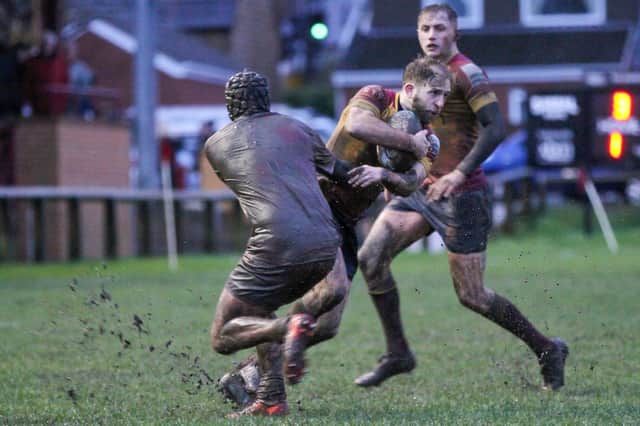 A mud covered Rossendale player tries to halt this Sandal attack.  Picture: Simon Hall