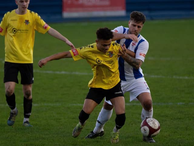 Pontefract Collieries' Joao Rangel and Liversedge FC's Adam Field battle for the ball in the New Year's Day derby at Clayborn.