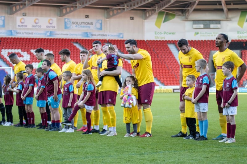 Emley players line up with the club's mascots before the cup final.