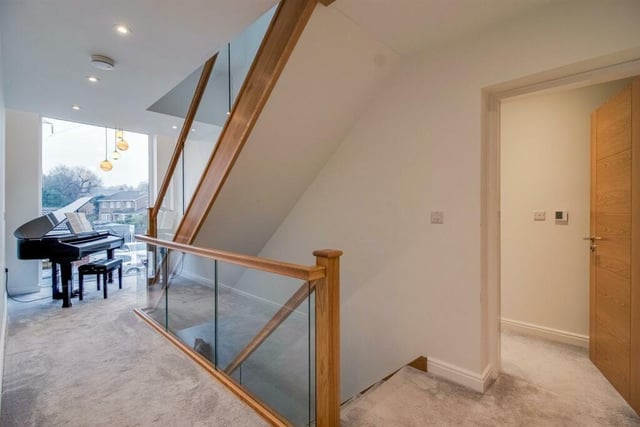 The landing includes a large picture window to the front and a return staircase from the ground floor to the first floor with an oak and glass balustrade.