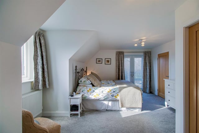 A stylish double bedroom with patio doors leading outside.