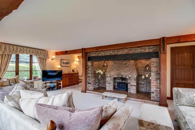 A large and bright reception room with feature open rustic fireplace