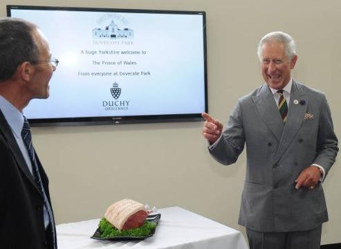 Britain's Prince Charles, Prince of Wales reacts after being given a joint of beef after his tour Dovecote Park in Pontefract, West Yorkshire on July 22, 2013. Prince William's wife Kate was admitted to hospital on Monday in the early stages of labour as the world awaited the birth of a baby directly in line to inherit the British throne.