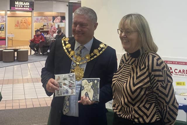 Wakefield's Mayor CounDavid Jones with Card for Good Causes shop manager Jill Farringdon.